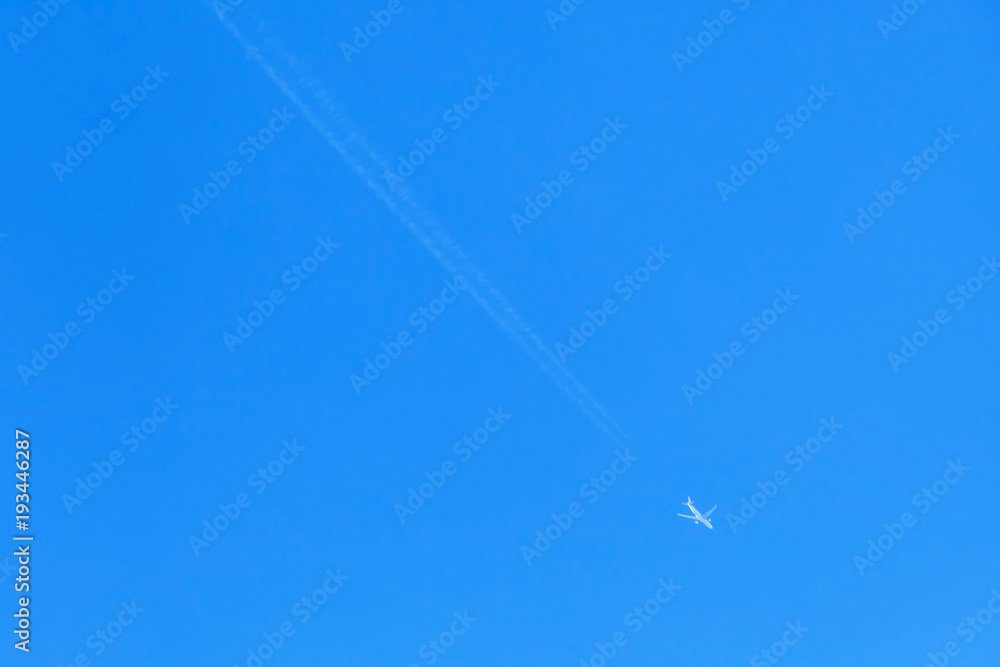 Jet plane with long trail in blue sky Jet plane with long trail in blue sky