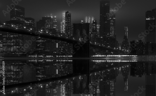 Black and white night view of Brooklyn Bridge and Manhattan downtown skyline