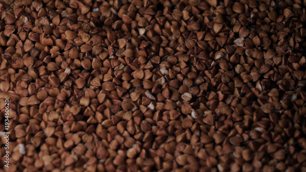 Buckwheat falls on a white plate, a black background. Buckwheat falls on a white plate, a black background.