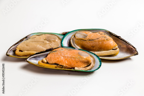 Mussels in the shell lie on a white background