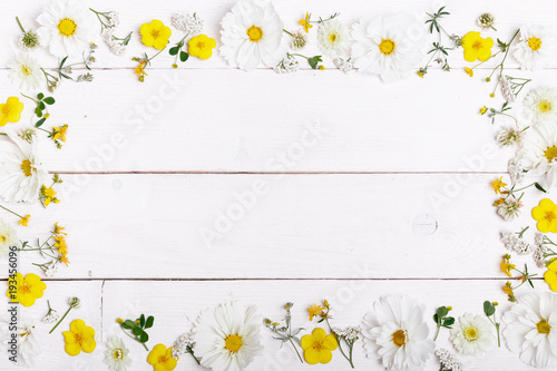 Fototapeta Naklejka Na Ścianę i Meble -  A bouquet of white flowers cosmea or cosmos with ribbon on white boards. Garden yellow flowers over handmade wooden table background. Backdrop with copy space.