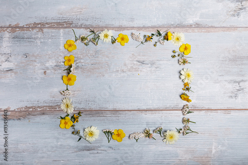 Fototapeta Naklejka Na Ścianę i Meble -  A bouquet of white flowers cosmea or cosmos with ribbon on white boards. Garden yellow flowers over handmade wooden table background. Backdrop with copy space.