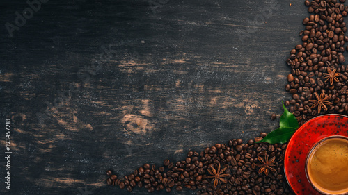 Hot coffee American in a cup. Cinnamon. On a black wooden background. Top view. Copy space. photo