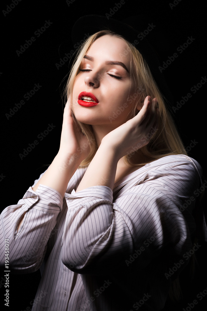 Tender blonde woman wearing white blouse, posing in the dark at studio Tender blonde woman wearing white blouse, posing in the dark at studio
