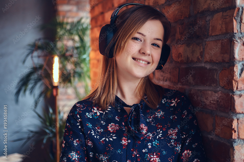 Portrait of a happy charming blonde in headphones listening to m Portrait of a happy charming blonde in headphones listening to m