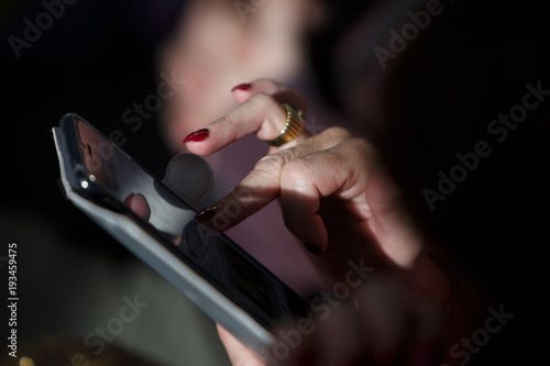 Fingers typing on a cellular phone display