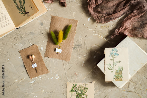 Flay lay, top view of the herbarium, dried lavender flowers, notebook, book for notes, pen and spring summer pictures on a concrete backgroundPostcard on kraft paper photo