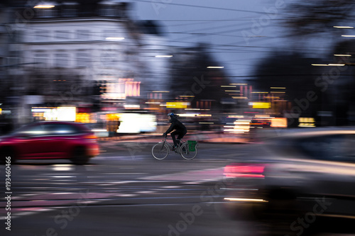 A cyclist drives at twilight over a road intersection photo