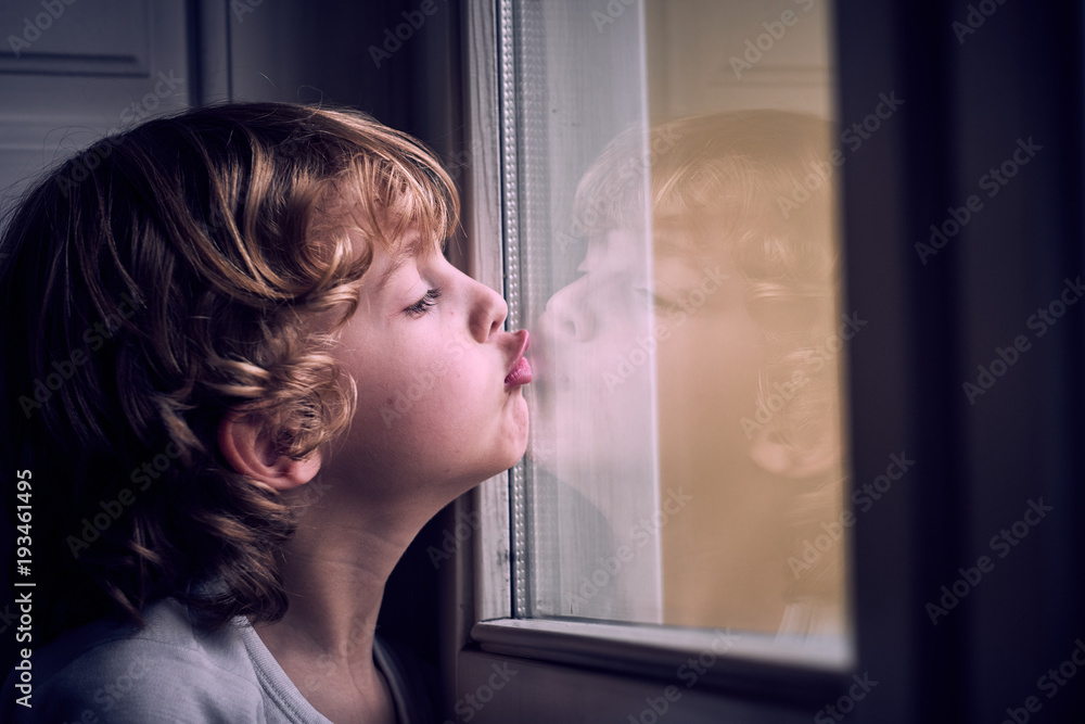 Adorable boy looking at window Adorable boy looking at window