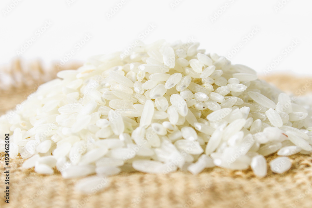 Grains of raw white rice on a white wooden table of boards. Ingredients for cooking. Grains of raw white rice on a white wooden table of boards. Ingredients for cooking.