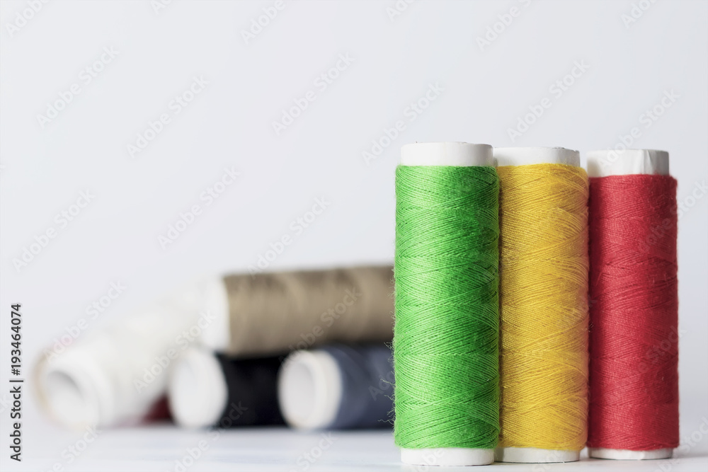 Accessories for sewing lie on a white background. Multicolored coils of threads. Accessories for sewing lie on a white background. Multicolored coils of threads.