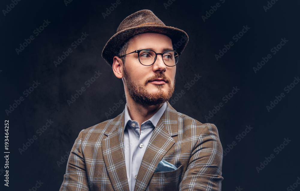 Studio portrait of a bearded hipster in hat and glasses wearing Studio portrait of a bearded hipster in hat and glasses wearing