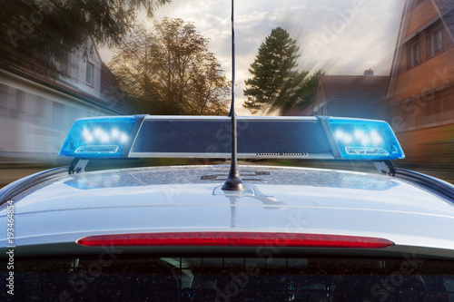 Polizeiauto mit Blaulicht im Einsatz im Wohngebiet © OFC Pictures