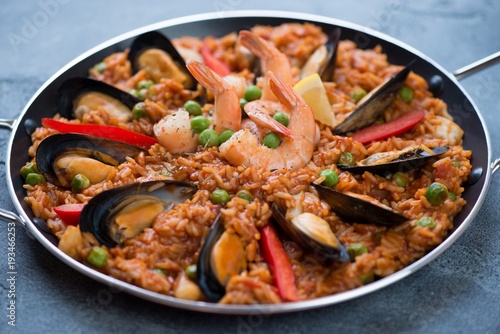 Spanish paella with seafood in a frying pan, selective focus, horizontal shot