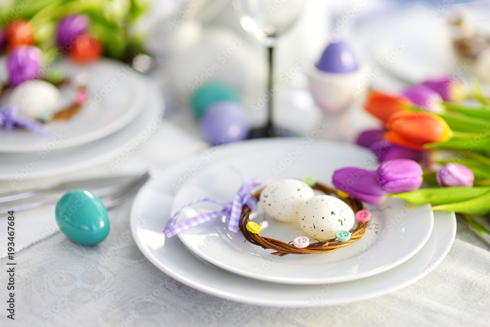 Beautiful table setting with crockery and flowers for Easter celebration Beautiful table setting with crockery and flowers for Easter celebration