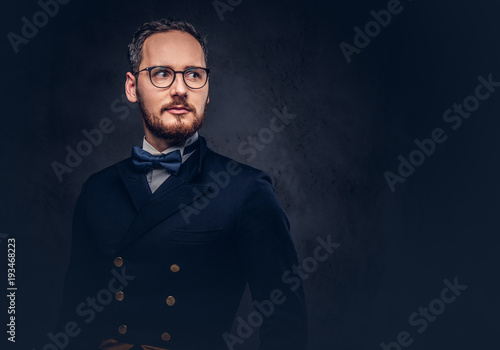 Portrait of a bearded male in glasses and antique suit on a dark photo