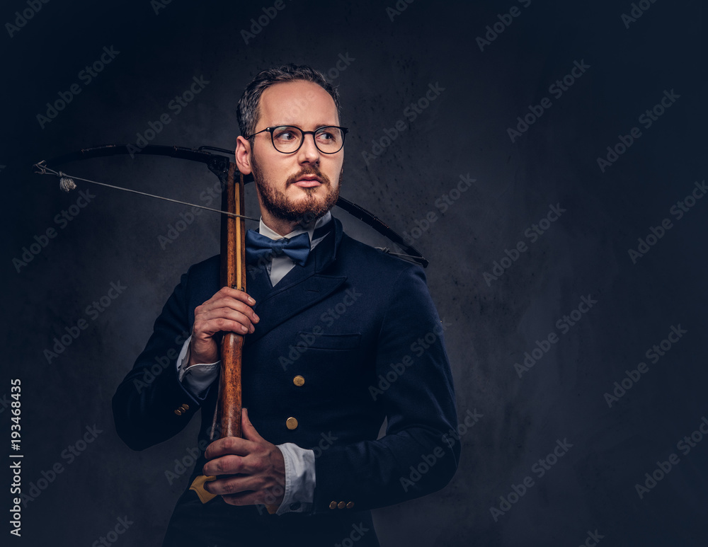 Portrait of a bearded male in glasses and antique suit holds cro Portrait of a bearded male in glasses and antique suit holds cro
