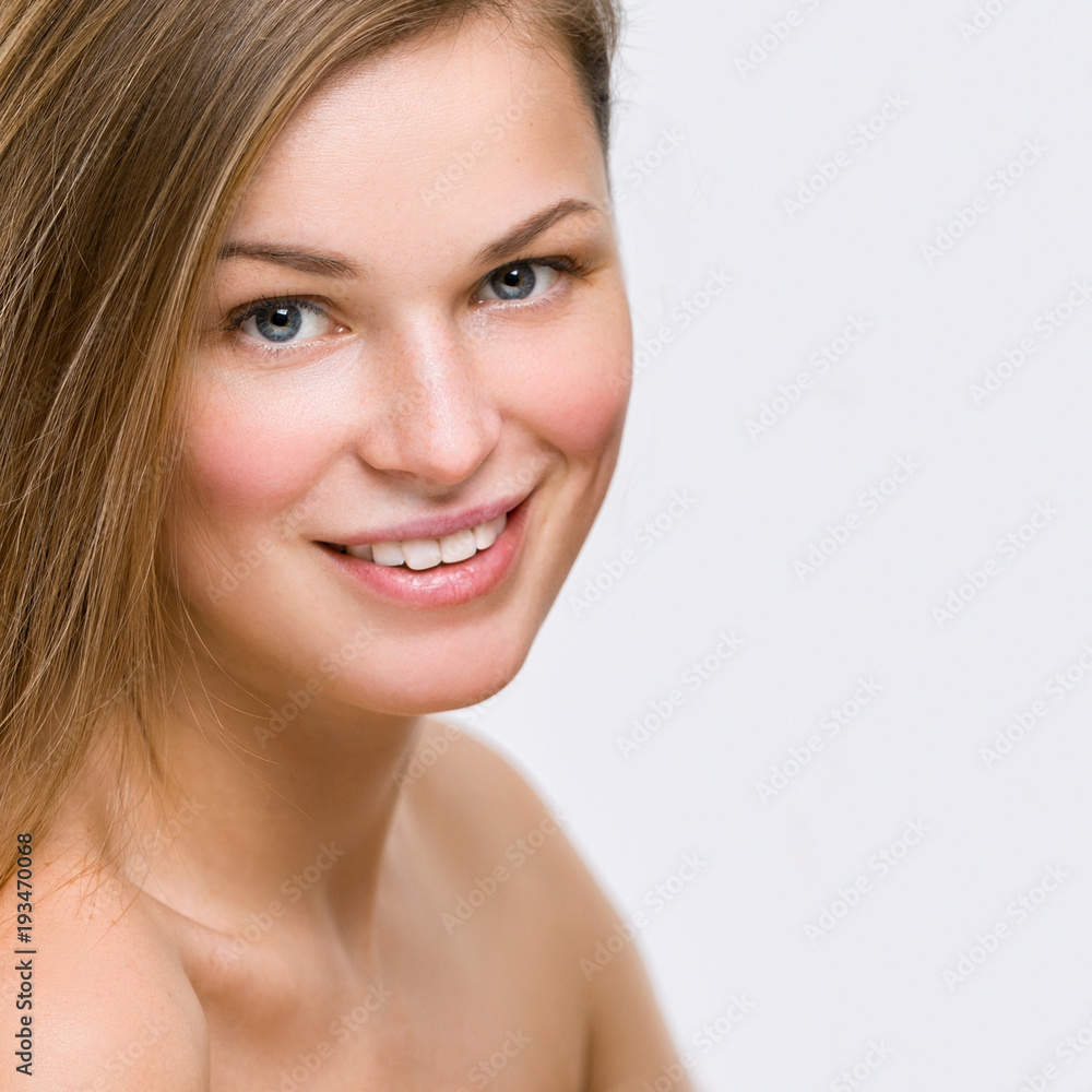 Portrait of a beautiful young smiling woman on a gray background Portrait of a beautiful young smiling woman on a gray background