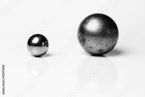 Две металлических сферы разных размеров изолированные на белом фоне. 