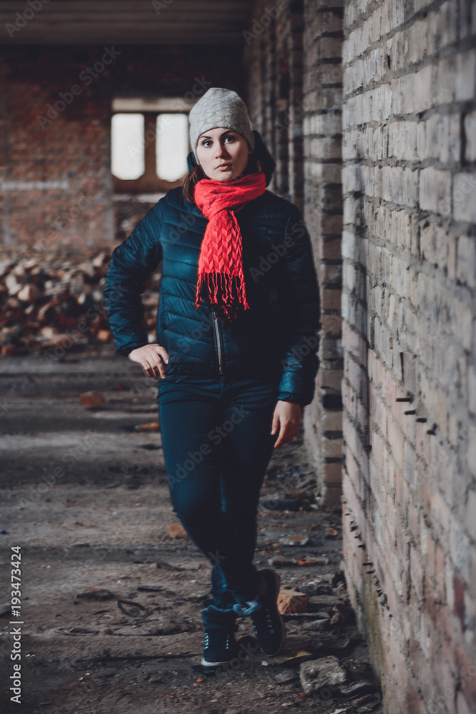 Beautiful young woman standing in a destroyed building in cold drowning Beautiful young woman standing in a destroyed building in cold drowning