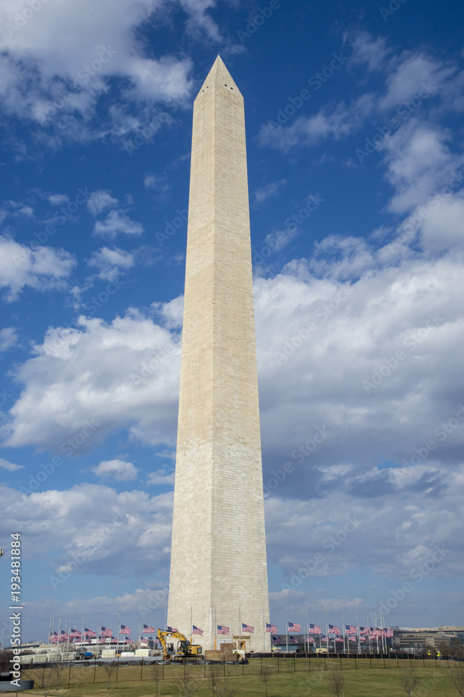  Vertical view of the Washington Monument on a windy day. Flags are at half staff in memory of the victims of the school shooting in Parkland, Florida, February 14, 2018.