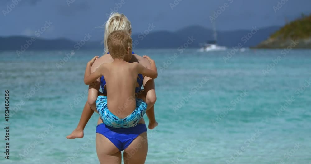 slow motion video of mother and child piggy back ride on tropical beach slow motion video of mother and child piggy back ride on tropical beach