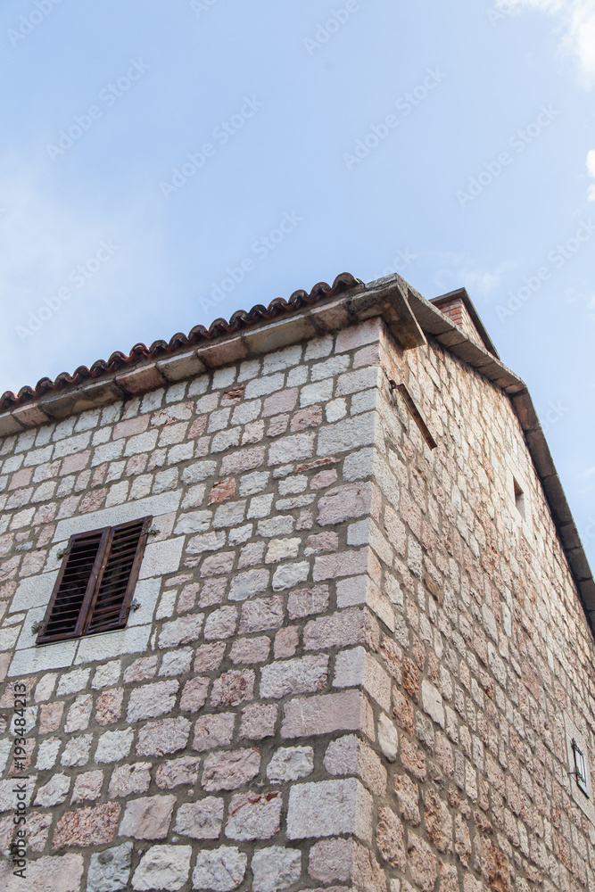 old stone wall of a building with a window. Montenegro