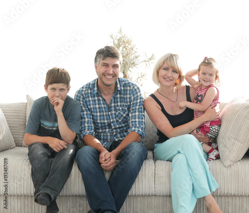 Young couple with their cute kids having rest at home