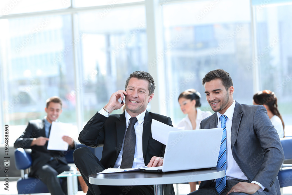 serious businessman talking on mobile phone sitting at your Desk serious businessman talking on mobile phone sitting at your Desk