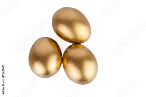 Three golden eggs isolated on white background