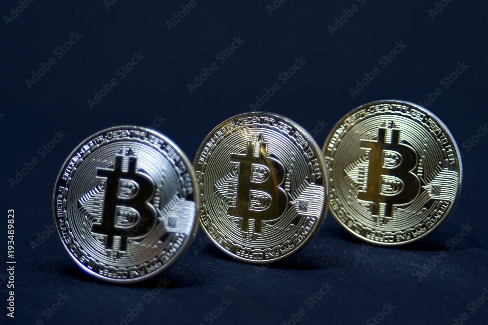 Three coins of bitcoin on black background.