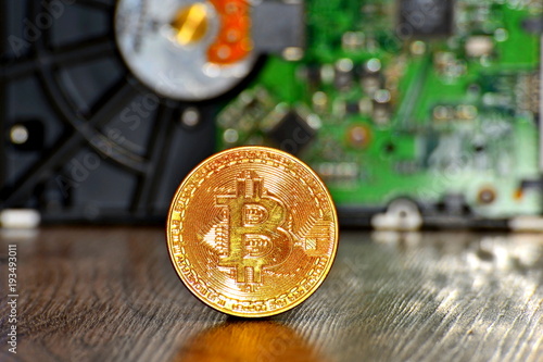 Gold coin bitcoin against the backdrop of mining and farm, close-up. Extraction of crypto currency. photo