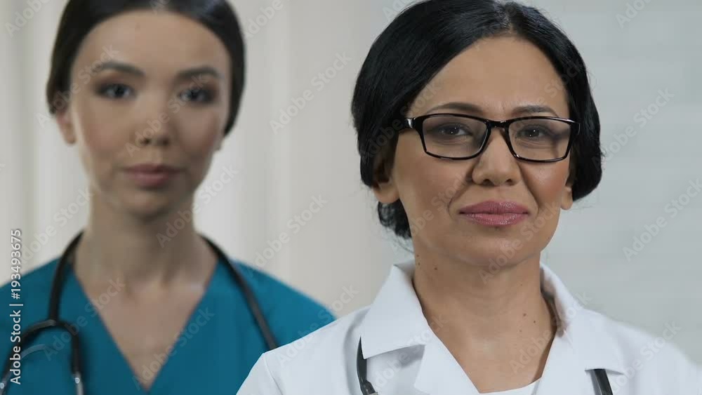 Professional doctors looking into camera and advertising new modern clinic Professional doctors looking into camera and advertising new modern clinic
