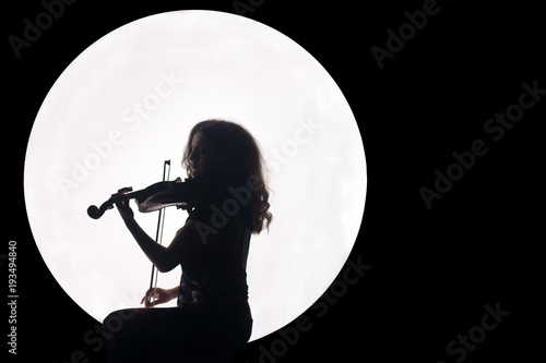 Fototapeta Sylwetka dziewczyny w białym kole ze skrzypcami w dłoniach. Pojęcie. Muzyka na pełnię księżyca. Nocne tło. Skopiuj miejsce.