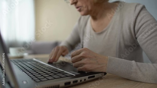 Retired lady studying new computer program, angrily pressing keyboard buttons