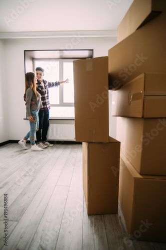Happy young couple planning decoration when moving home sitting near window with full boxex room © F8  \ Suport Ukraine