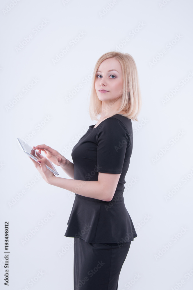 Woman looking in white tablet in her hands. Close up of young blonde beautiful girl in black dress using tablet. Technology concept Woman looking in white tablet in her hands. Close up of young blonde beautiful girl in black dress using tablet. Technology concept