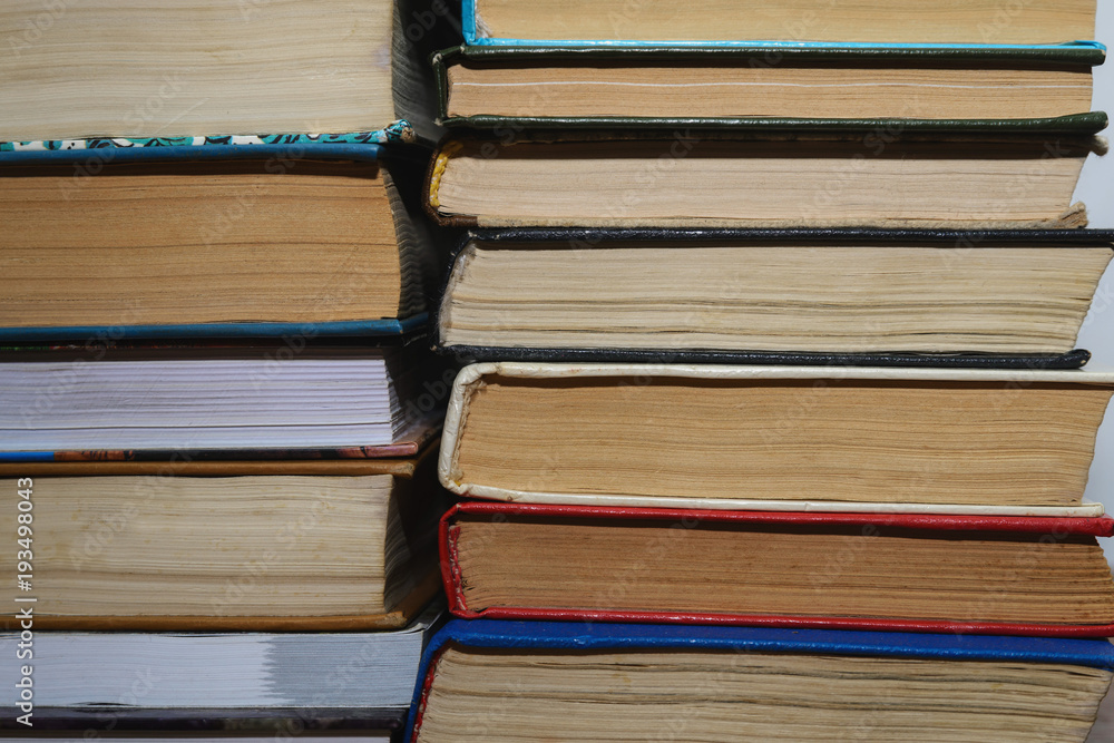 Naklejka premium Stack of different books on a woogen table
