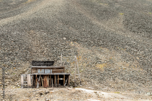 Old building used for the coal mining industry at Svalbard. Landscape of glacial moraine rocks in Longyear valley, Svalbard. Arctic landscape. photo