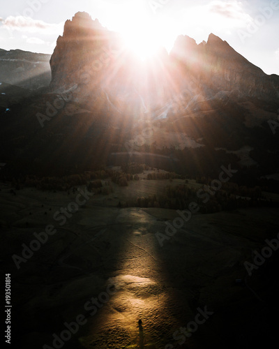 Sunrise over Dolomites Alpe di Siusi with single tree right where the sunbeam hits