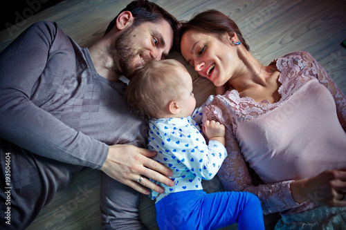 young parentswith their little daughter on the floor. Happy family concept