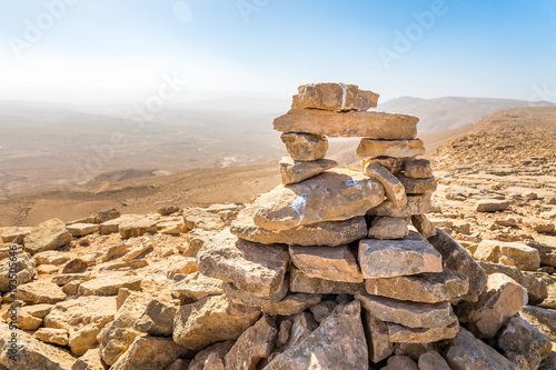 Stone cairn top mountain hiking trail sign, Israel desert.