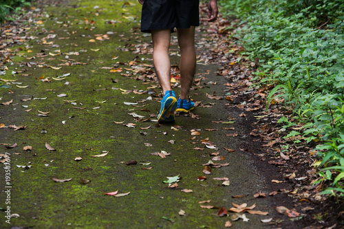 marathon runner running in rocks mountain. closeup of legs compression socks and shoes