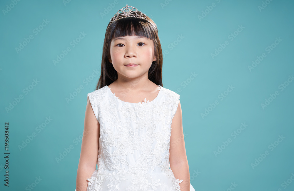 Portrait of little young cute asian girl wear like a princess . isolated on light green background .