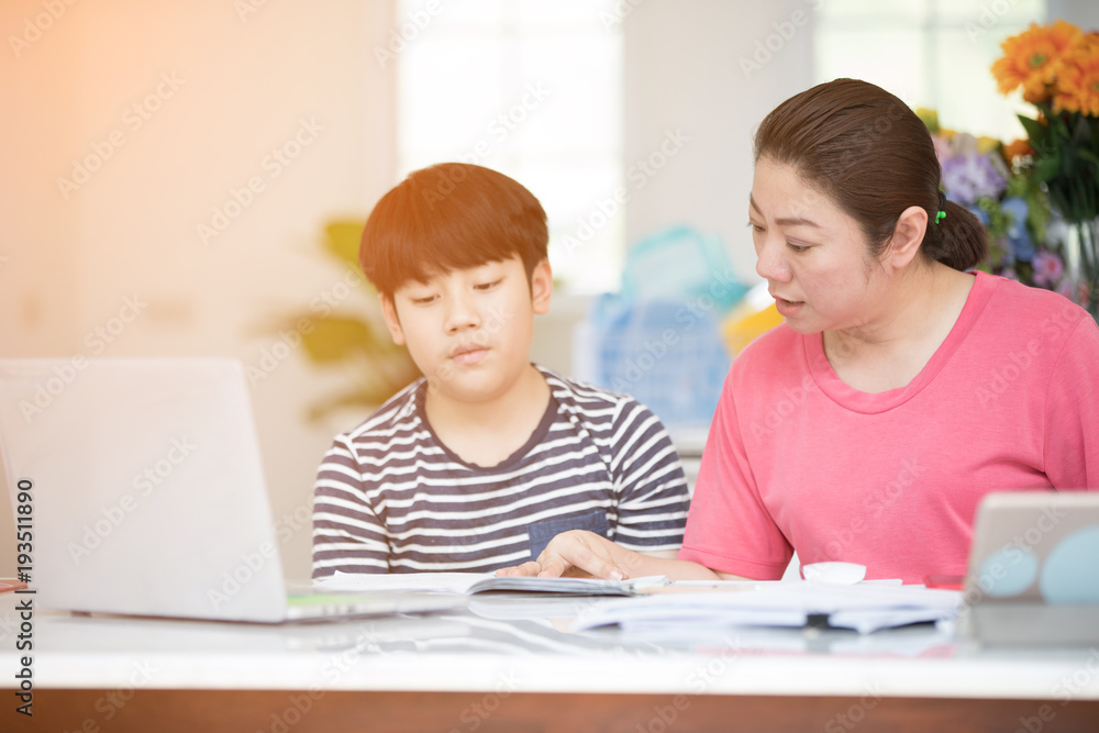 Asian boy with mother teaching and learning your homework at home Asian boy with mother teaching and learning your homework at home
