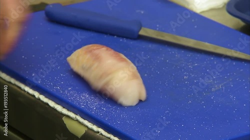 A medium shot of a monkfish's meat that is being put by different spices like salt and pepper.
