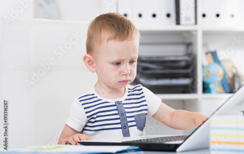 Cute child is watching cartoons on laptop