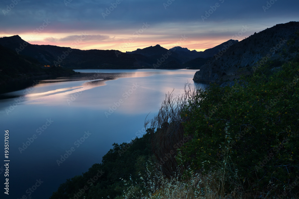Summer mountains landscape with lake in sunset