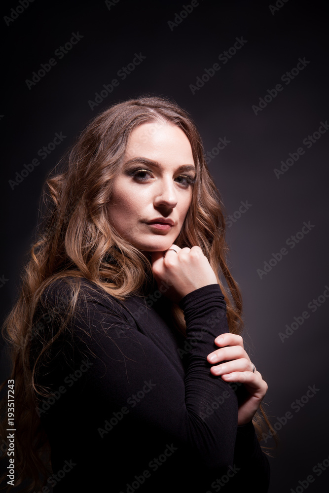 Portrait of a beautiful girl with long hair on a dark background in the studio Portrait of a beautiful girl with long hair on a dark background in the studio
