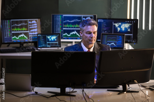 Stock Market Broker Looking At Multiple Computer Screen